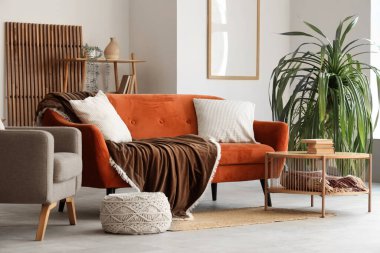 İçinde rahat kahverengi kanepe, masa ve koltuk olan oturma odası.