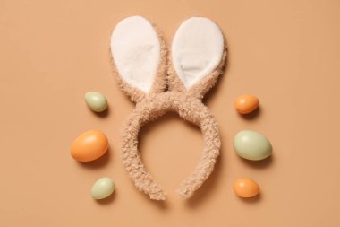 Kahverengi arka planda Paskalya yumurtası olan tavşan kulaklı.