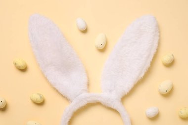 Bej arka planda Paskalya yumurtası olan tavşan kulaklı.