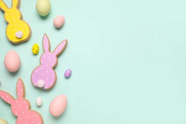 Turkuaz arka planda Paskalya yumurtalı tahta tavşanlar.