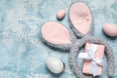 Paskalya yumurtalı tavşan kulakları ve grunge arka planında hediye kutusu.