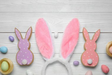 Beyaz ahşap arka planda Paskalya yumurtası olan tavşan kulaklı.
