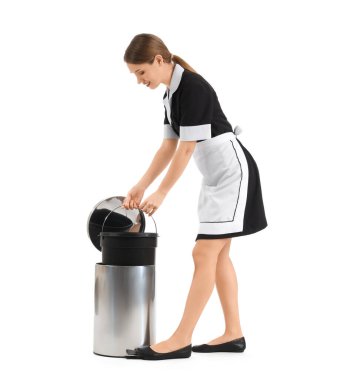 Beyaz arka planda çöp tenekesi olan güzel oda hizmetçisi.