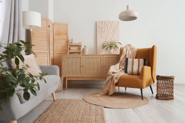 Rahat koltuk, katlanabilir ekran ve beyaz duvarın yanındaki çekmeceler oturma odasının şık iç kısımlarında.