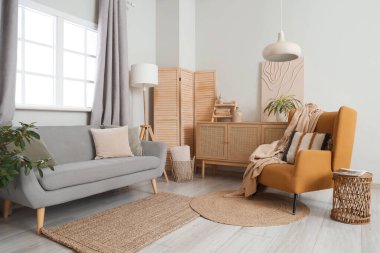 Beyaz duvarın yanındaki rahat koltuk ve koltuk oturma odasının şık iç kısımlarında.