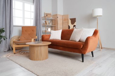 Deri koltuk, rahat kanepe ve şık bir oturma odası içinde ahşap masa.