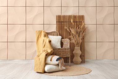 Hasır koltuklu ve bej döşeme duvarının yanında katlanır ekran olan odanın içi