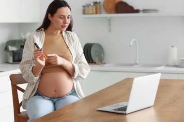 Elinde tükenmez kalemle mutfakta sohbet eden hamile bir kadın. Gebelik Diyabet Konsepti