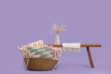 Dekoratif yastıklı sepet ve leylak arka planda bank