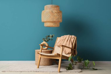 Ekoseli ve okaliptüs dallı, mavi duvarın yanındaki sehpanın üstündeki vazoda.