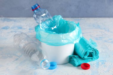 Çöp torbaları, plastik şişeler ve renkli kapaklı kapaklar.