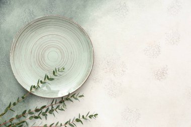 Arkaplanda tabak ve bitki dalları olan şık masa ayarları