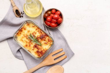 Lezzetli makarna, biberiye, biber, domates ve hafif arkaplanda bir sürahi yağ.