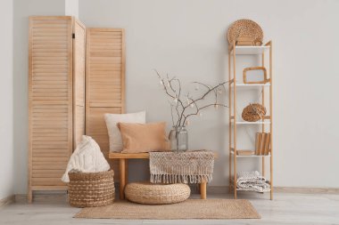 Ağaç dalları ve bayram salonundaki bankta Paskalya yumurtaları olan vazo.