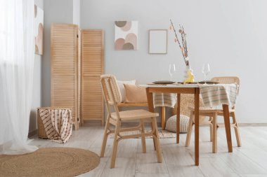 Ağaç dalları ve Paskalya yumurtaları olan vazo şenlikli yemek salonunda servis edilen masada.