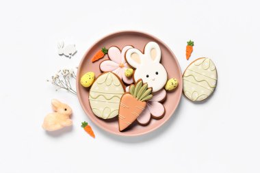 Dekorlu kompozisyon ve beyaz arka planda izole edilmiş tabakta farklı Paskalya kurabiyeleri