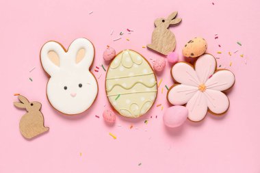Yumurta, çiçek ve pembe arka planda tavşan şeklinde Paskalya kurabiyeleri.