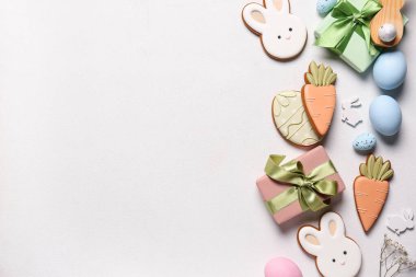 Yumurtalı kompozisyon, hediye kutusu ve beyaz arka planda farklı Paskalya kurabiyeleri.