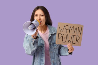 Plaketi olan genç Asyalı kadın leylak arka planda megafona bağırıyor.