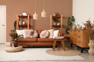 Rahat bir kanepe, sandık dolusu çekmece ve oturma odasının içindeki raf üniteleri.