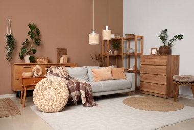 Çekmece sandığı, oturma odasının içinde ekoseli rahat bir kanepe ve puf.