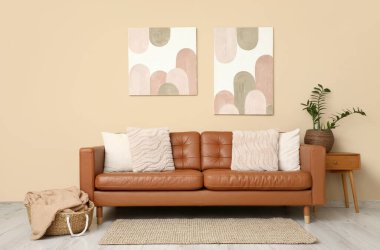 Rahat bir kanepe, oturma odasının iç tarafındaki komodinli ve çiçekli sepet.