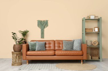 Konforlu kanepe, raf ünitesi ve oturma odasının iç tarafındaki saksılar.