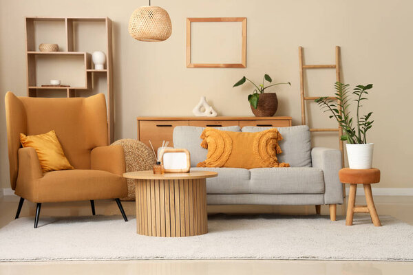 Интерьер гостиной с удобным диваном, креслом и столом возле бежевой стены