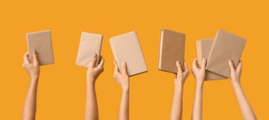 Sarı arka planda bir sürü kitap tutan eller