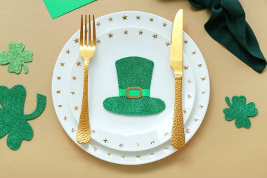 Beautiful table setting for St. Patrick's Day celebration on beige background