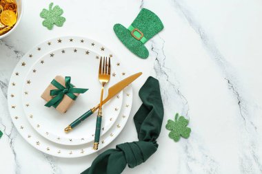 Beautiful table setting for St. Patrick's Day celebration on white marble background