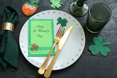 Beautiful table setting for St. Patrick's Day celebration on black background