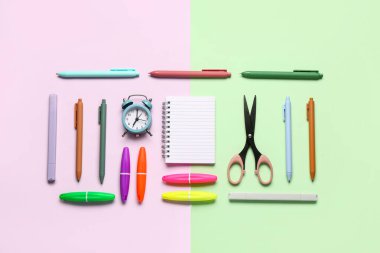 Renkli arkaplanda farklı kırtasiye malzemesi olan defter