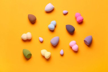 Turuncu arka planda farklı makyaj süngerleri