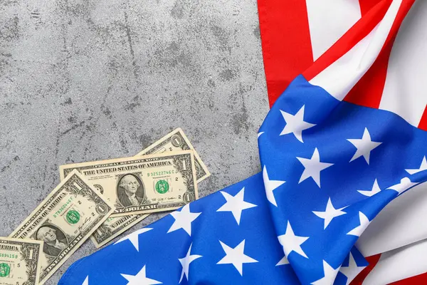 ABD bayrağı ve gri arka planda dolar banknotları