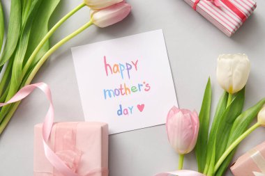 Kısa arkaplanda Mutlu Anneler Günleri, hediye kutuları ve lale çiçekleri olan kart, yakın plan.