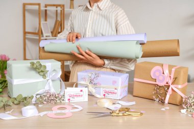 Ambalaj kağıtları ve güzel hediye kutuları olan bir kadın. Uluslararası Kadınlar Günü