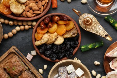 Koyu arkaplanda geleneksel Doğu tatlıları, Aladdin lambası ve Ramazan için tasbih kompozisyonu