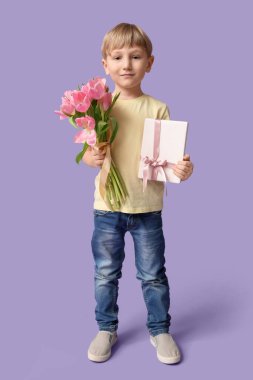 Güzel lalelerle dolu buketi ve leylak arkaplanlı hediye kutusu olan sevimli küçük bir çocuk. Uluslararası Kadınlar Günü