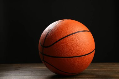 Siyah arka plana karşı tahta masada basketbol oynamak için top