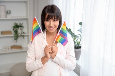 Yatak odasında LGBT bayrakları olan güzel genç bir kadın.
