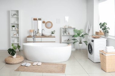 Banyonun içinde küvet, çamaşır makinesi ve hasır paspas var.