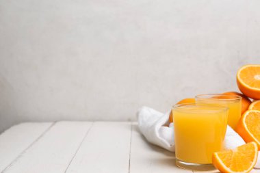 Portakallı ve beyaz ahşap masadaki peçeteli lezzetli meyve suları.