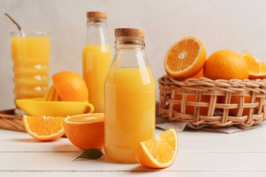 Beyaz ahşap masada portakallı bir şişe lezzetli meyve suyu.