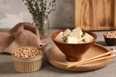 Gri arkaplanda lezzetli tofu peyniri olan kase.