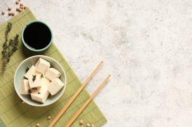 Hafif grunge arka planında lezzetli tofu peyniri ve soslu kase.