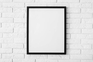 Beyaz tuğla duvara asılı boş poster