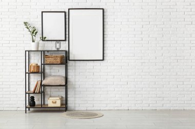 raf ünitesi ve beyaz tuğla duvara boş posterler