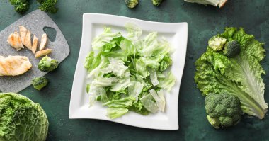 Taze sebzeli lezzetli salata ve yeşil arka planlı tavuk için malzemeler.