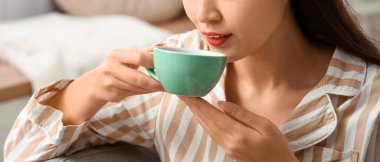 Güzel genç bayan, sabahları sıcak çay içiyor, yakından.